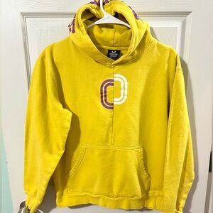 Overtime kid’s yellow hoodie with a purple and white logo.